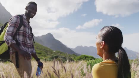 african american couple high fiving each other while trekking in the mountains