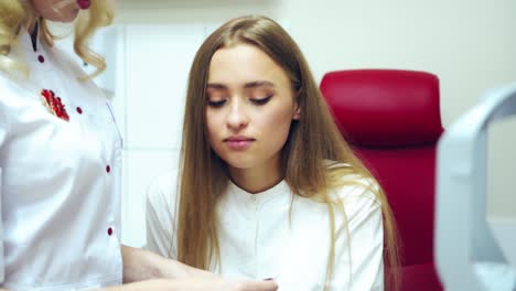doctor with patient in medical office. young woman having eyes examined by eye doctor