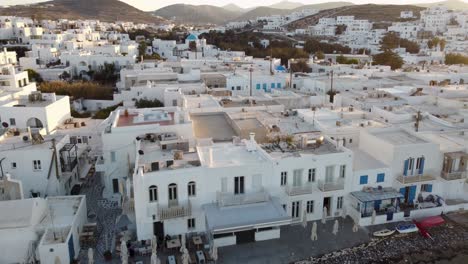 astonishing shot of approaching the picturesque naoussa village of paros during summer sunset in greece from the sea and a beach