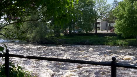 agua de río que fluye rápido en un día soleado