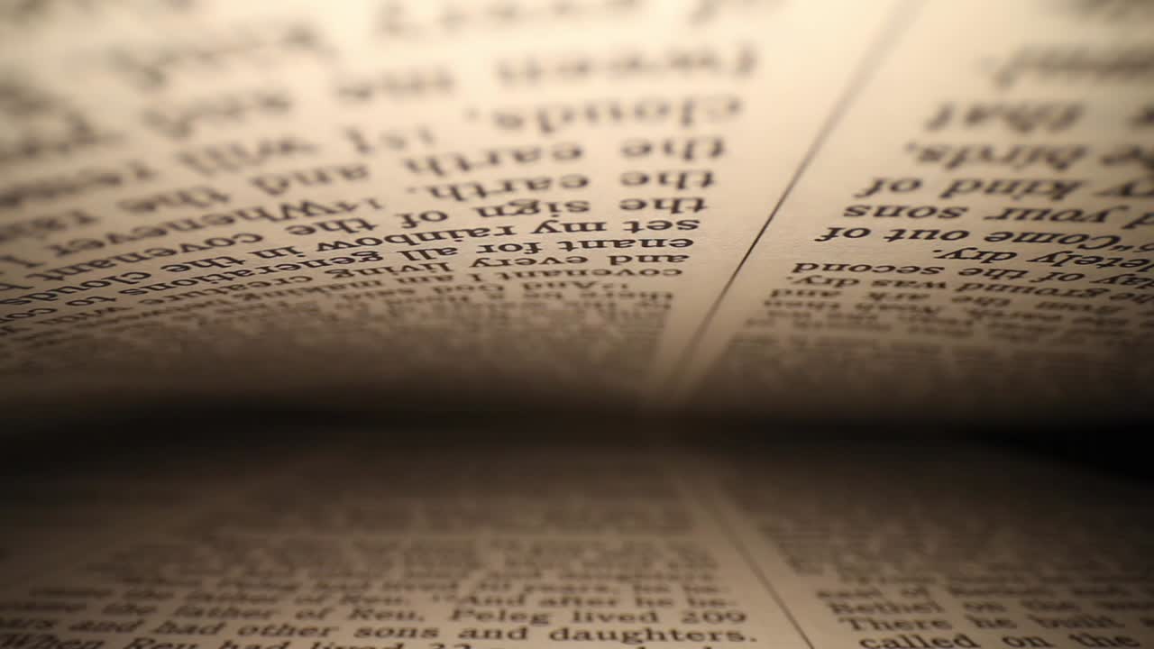 moving laterally through a book right to left, pages on top - bottom of frame as it passes down to the end