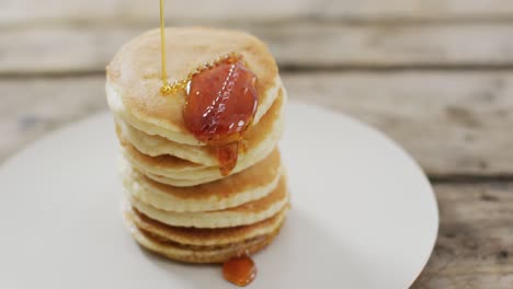 video of pancakes with maple syrup on white plate seeing from above