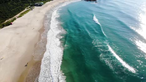 aerial pan drone shot of people at sea and mountains in summer brazil, florianopolis