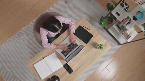 mujer trabajando desde casa en una computadora portátil