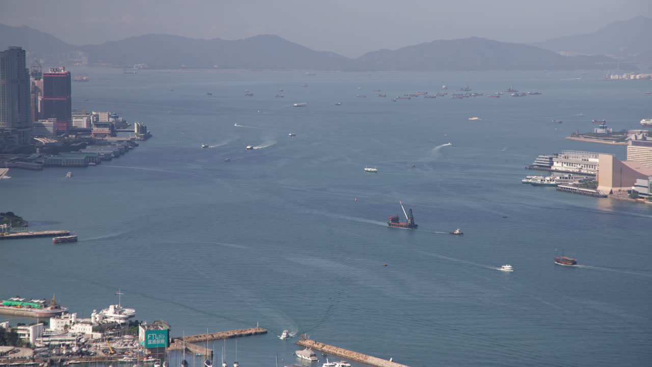 el tráfico marítimo del puerto de victoria de hong kong con transbordadores y buques de carga en el lapso de tiempo durante el día