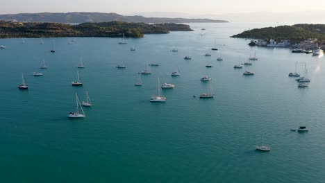 Luftdrohnenvideo-Aus-Der-Vogelperspektive-Des-Berühmten-Und-Malerischen-Yachtdocks-Am-Fjorddorf-Porto-Heli-Mit-Türkisfarbenem-Und-Smaragdgrünem-Klarem-Wasser,-Argolis,-Peloponnes,-Griechenland