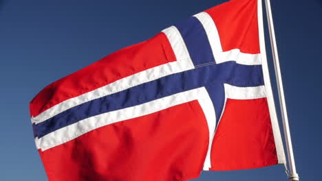 a norwegian flag waving in the wind