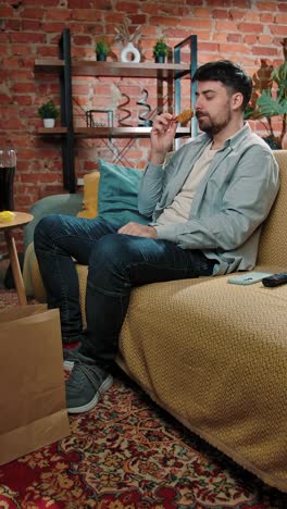 man eating fried chicken at home