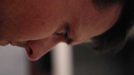 closeup of face and eyes of sad, angry, unhappy man in prison cell