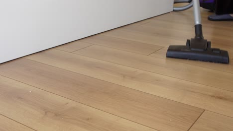 closeup of a vacuum cleaner cleaning a wood floor