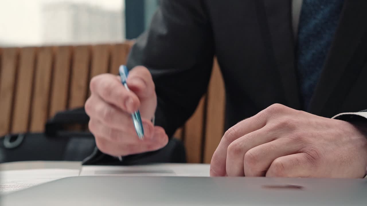 Businessman taking notes or signing contract, pen and document, man in formal jacket. Close up hand