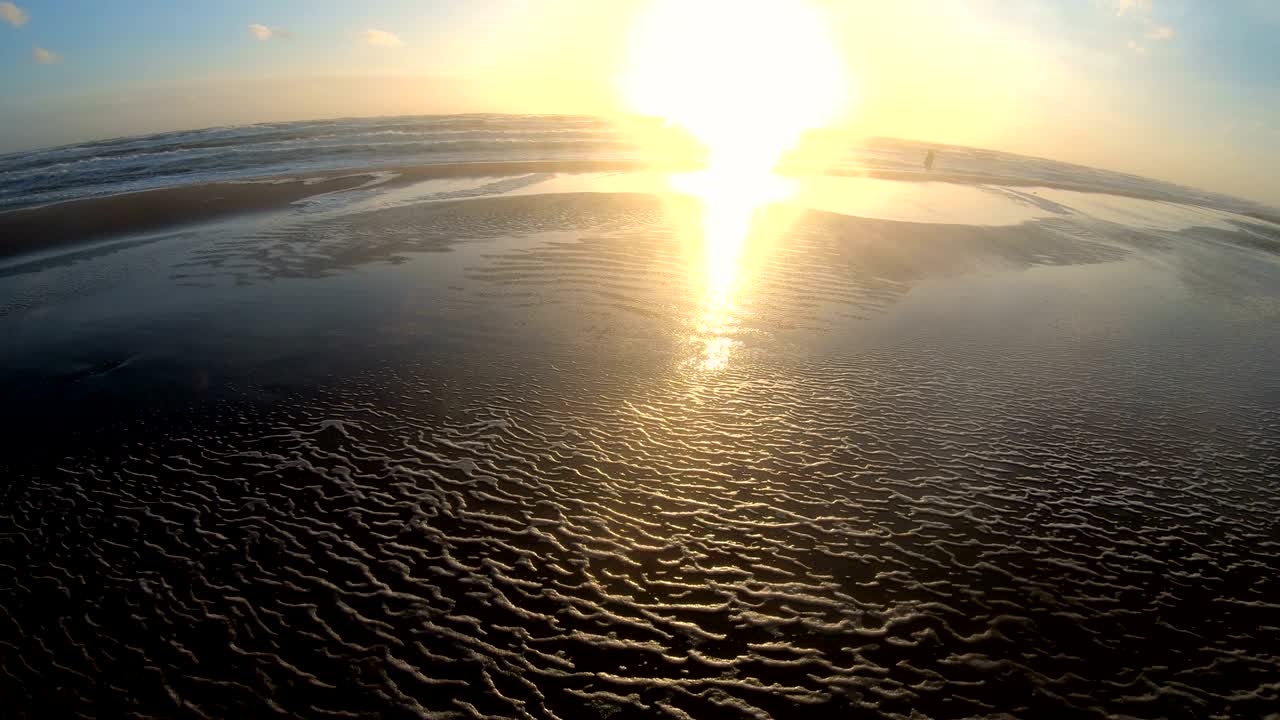 водоросли пена в шторме на пляже, одинокий человек на песчаном пляже с волнами, северное море, ютландия, сондервиг, дания, 4к