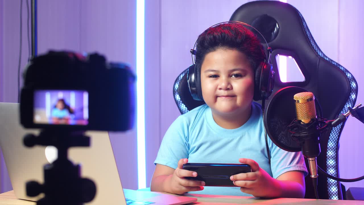 Asian Little Boy Playing Video Game With Mobile Phone Then Smiles To Camera While Live Stream