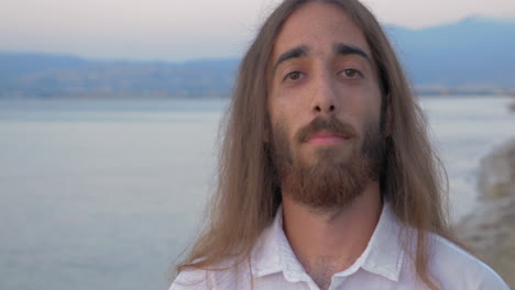 long-haired man with beard looking to the camera