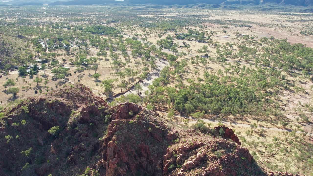 Aerial footage over the MacDonnell Ranges and the dry Roe Creek, in the Northern Territory, Australia. August 2022.