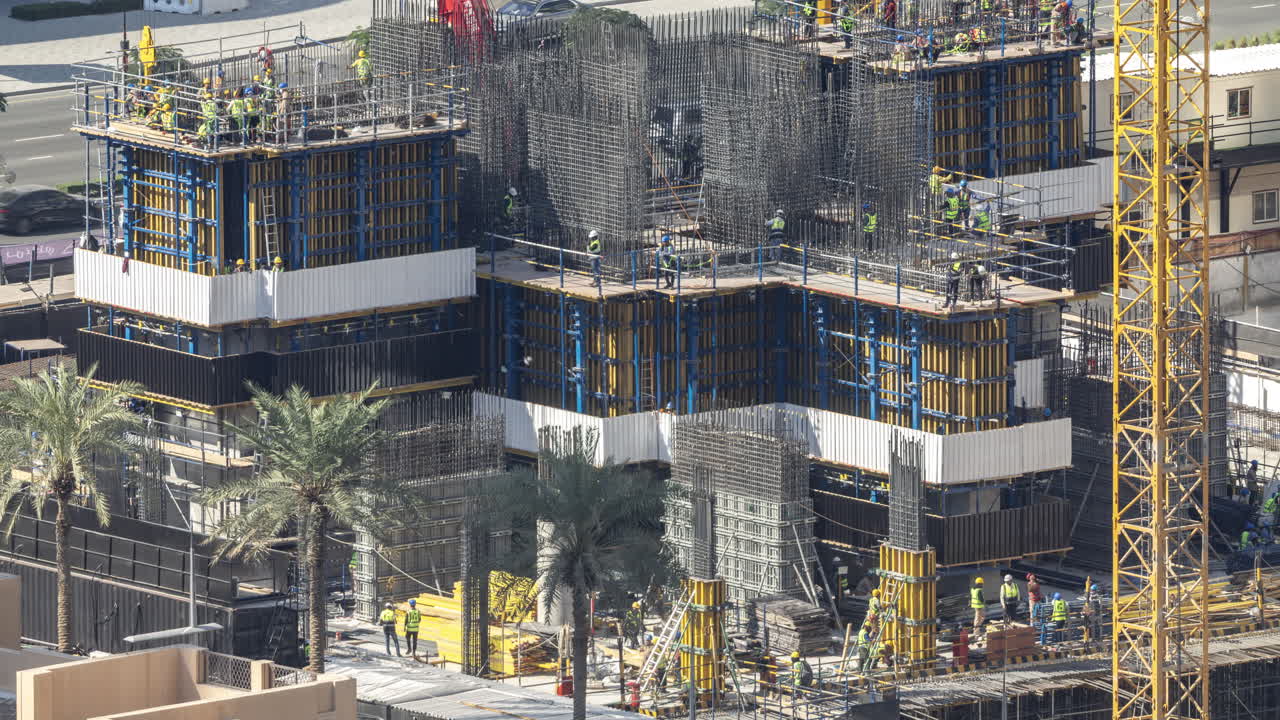 Construction Workers Building a Large Structure in an Urban Area