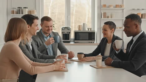 business colleagues enjoying a coffee break and conversation in the office breakroom