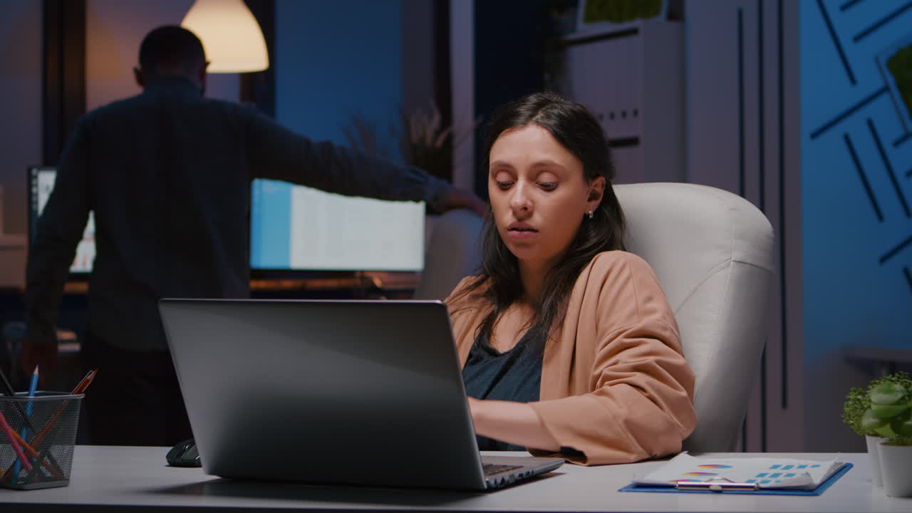 Workaholic entrepreneur woman sitting at desk table analysing financial graphics