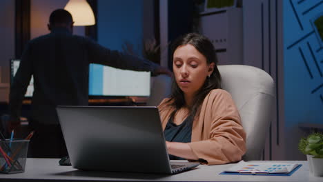 workaholic entrepreneur woman sitting at desk table analysing financial graphics