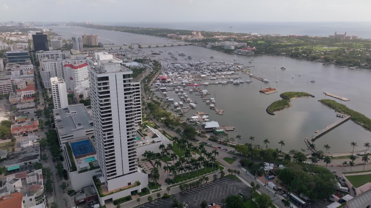 Aerial view of a bustling city waterfront with a marina full of yachts
