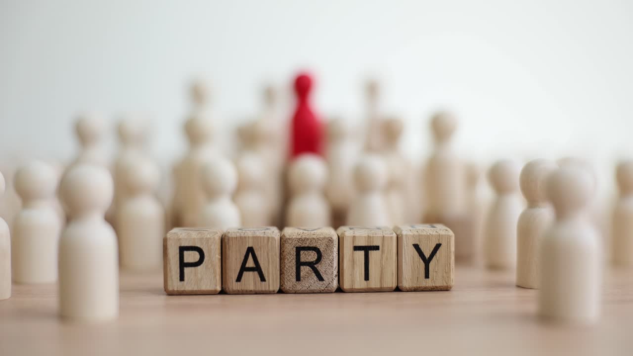 Wooden figures forming a group with the word "PARTY" spelled out in blocks