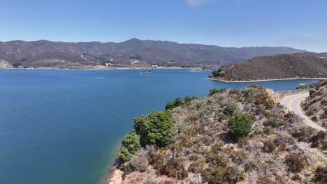 bewegt sich eine autobahn neben bouquet reservoir in santa clarita, kalifornien an einem sonnigen tag mit großen schwarzen vögeln im rahmen luft dolly pan 60fps