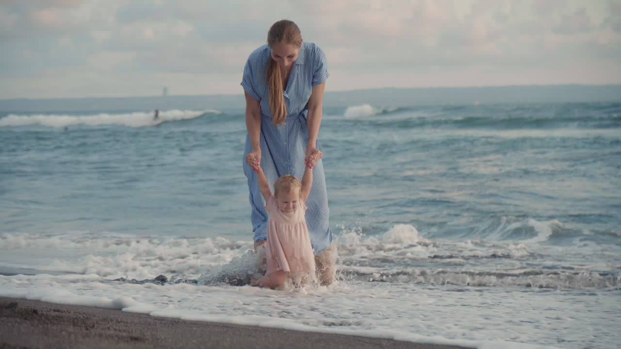 아기 바다 파도를 보여주는 엄마