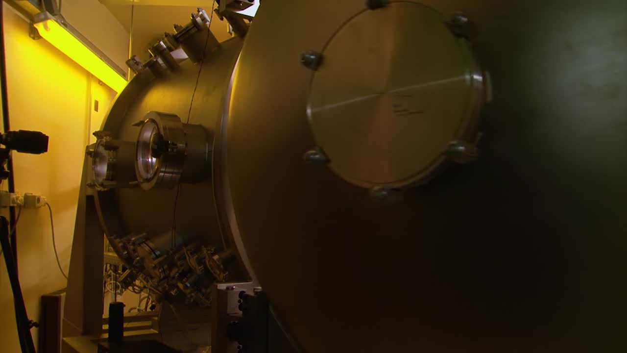 손으로 사이클로트론 입자 가속기를 엽니다.