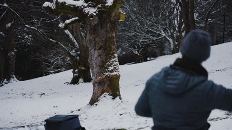 Black-labrador-dog-chases-after-snowball-thrown-by-owner,-slow-motion