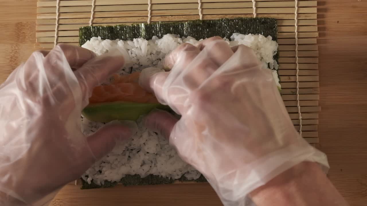 un chef preparando rollos de sushi en la cocina