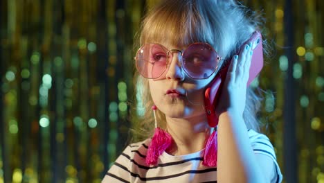 Girl-in-futuristic-glasses-talking-on-mobile-phone-with-friend-in-night-club-with-neon-blue-light