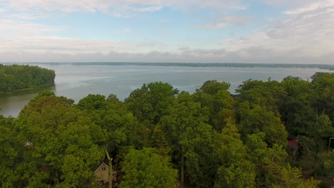 drone shot of indian lake in ohio, rising aerial shot from trees revealing the water