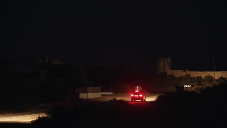 Coche-Circulando-Por-La-Carretera-Rural-Por-La-Noche.