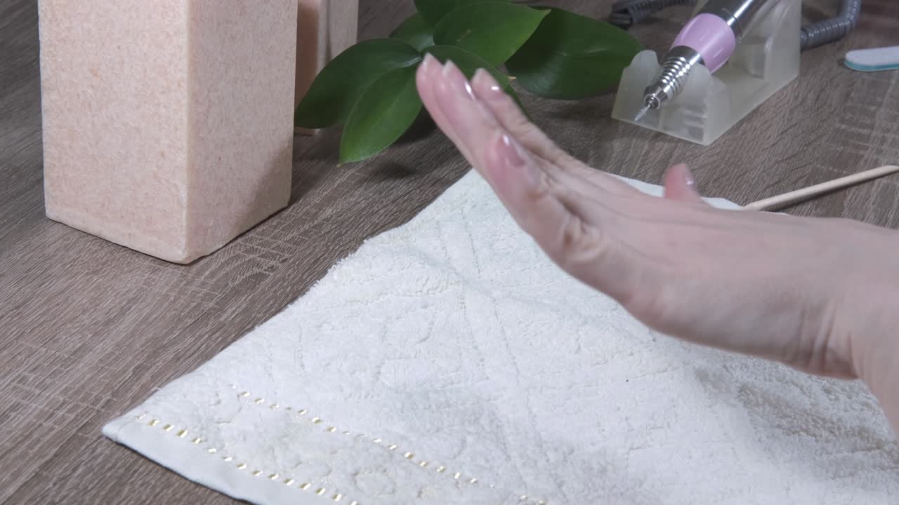 여성 매니큐리스트는 치료된 손과 보호 코팅으로 인 손을 봐야합니다. 매니큐어 또는 손 폴라쉬의 과정은 근접합니다.