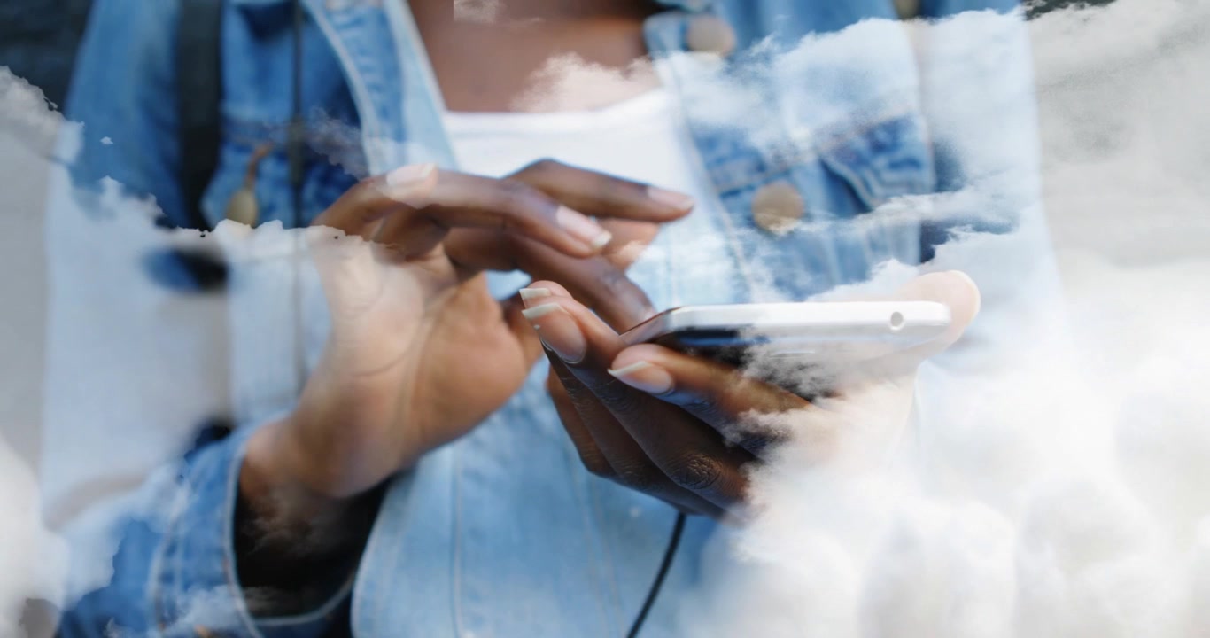 Woman tapping smartphone in tech and initiating drifting cloud layers enveloping screen and jacket