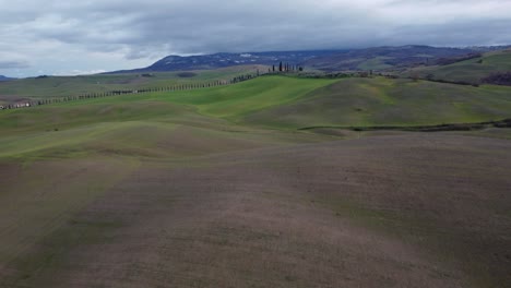 aérea sobre los típicos campos agrícolas de la toscana en un día nublado, italia