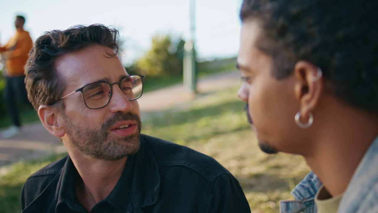 dos hombres hablando y riendo en un parque