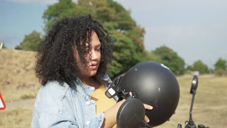 Young-woman-putting-her-helmet-off-after-a-drive-with-her-electric-scooter