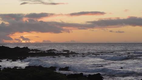 waves rushing and crashing on rocky hawaii beach at serene sunset