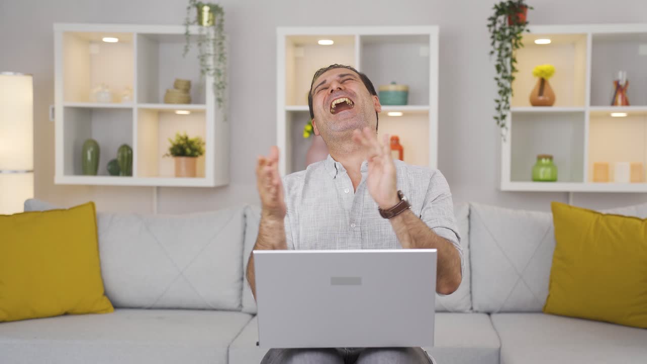 노트북을 보는 남자가 박수를 치고 있습니다.