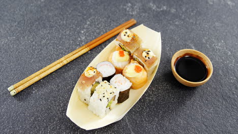 sushi on boat shaped plate with chopsticks