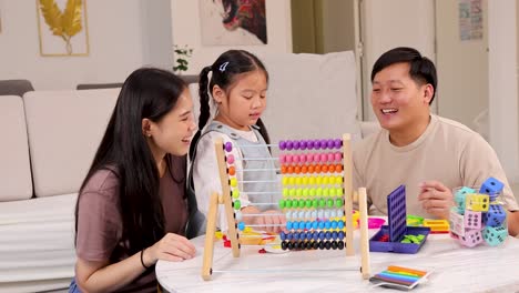 A family enjoys quality time using a colorful wooden abacus in a cozy, well-lit living room setting