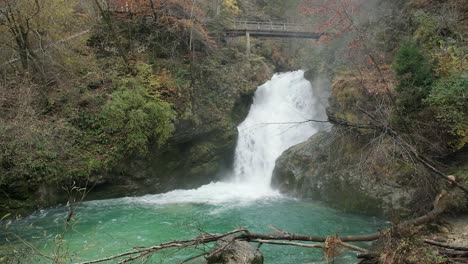 panorámica lenta potente cascada bosque verde agua turquesa puente día