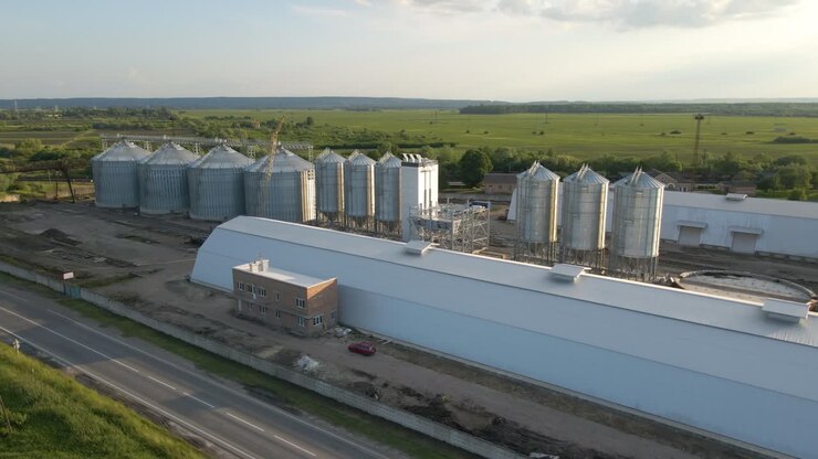 Aerial view of industrial ventilated silos for long term storage of grain and oilseed. Metal elevator for wheat drying in agricultural zone
