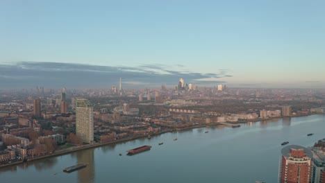 dolly forward drone shot towards central london skyline from canary wharf at sunrise