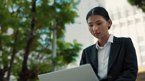 mujer de negocios trabajando en una computadora portátil al aire libre