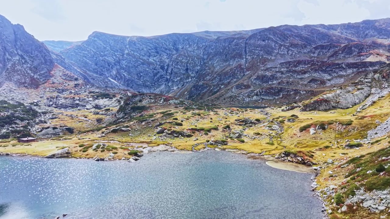 Gündüz vakti göl ve kayalık arazi içeren dağ manzarası