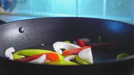 salteado de pimientos verdes y rojos con cebolla blanca en una sartén
