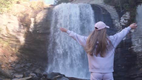 a woman and girl marvel at a waterfall embracing natures beauty a woman and a girl stand in awe before a majestic waterfall arms outstretched in joy and connection embodying empowerment and generational bonds