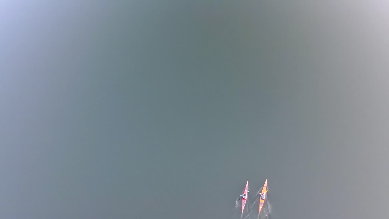 미네소타의 호수를 천천히 노를 젓는 두 대의 카약의 하향식 보기